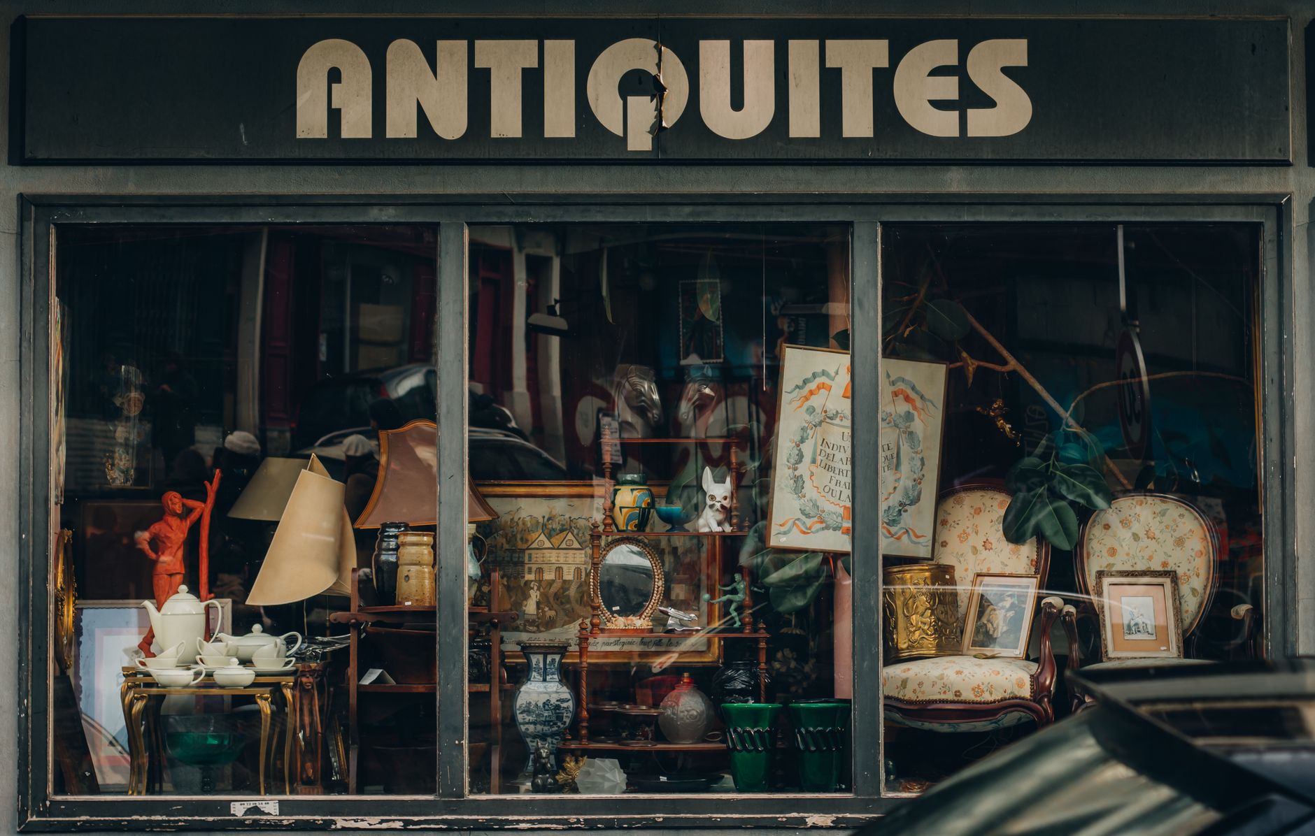 Fachada de loja de antiguidades com vitrine cheia de objetos